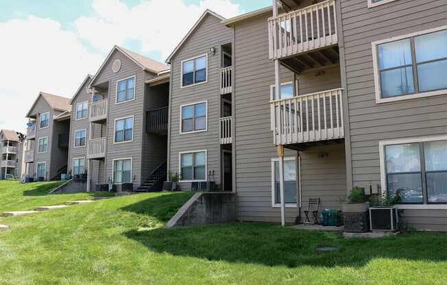 a row of apartment buildings with balconies and grass