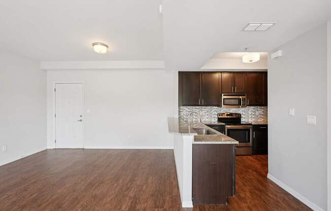 A kitchen with a white island and dark wood cabinets.