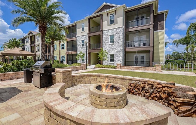 a fire pit with a grill in front of an apartment building  at Cabana Club - Galleria Club, Jacksonville