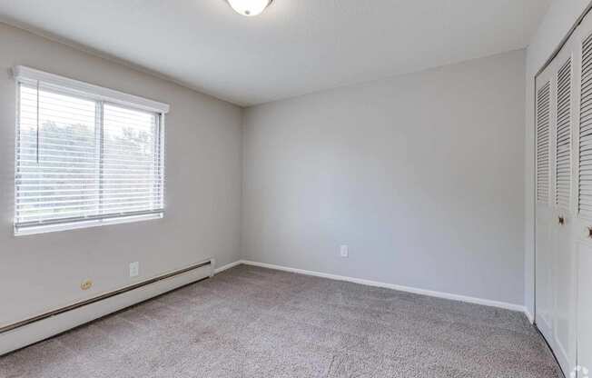 an empty living room with white walls and a window