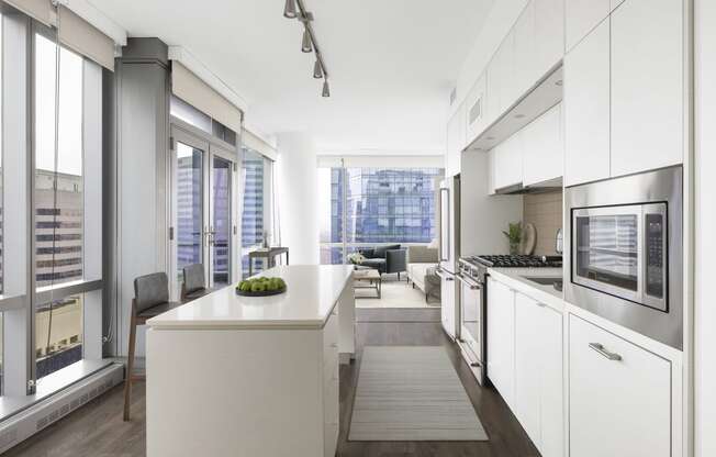 a kitchen with white cabinets and a white counter top and a living room
