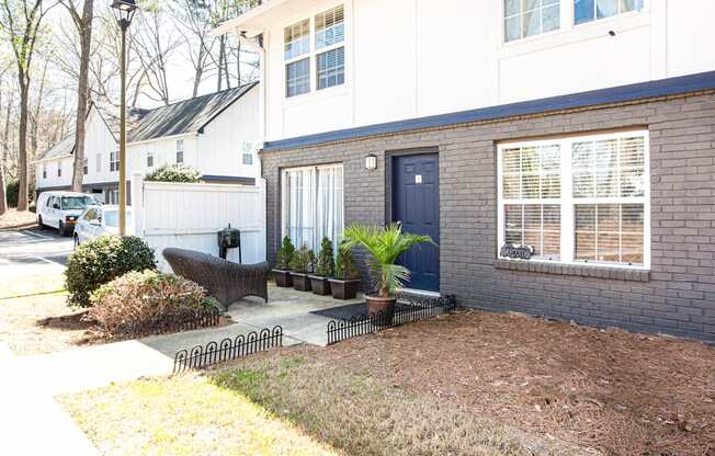 a home with a blue front door and a front yard with a bench and potted plants Barcelo at East Code Marietta, GA