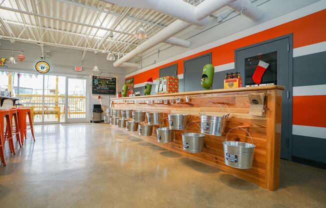 A long wooden table with metal buckets on it.