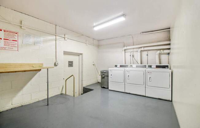 A clean, empty industrial room with white cabinets and a door at the back.