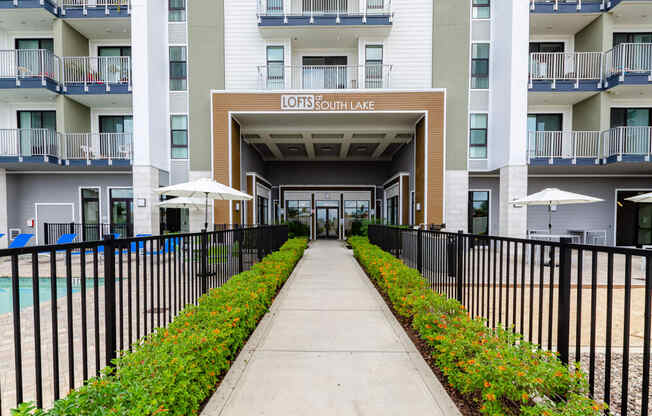 condominiums with a walkway and a fence in front of a pool
