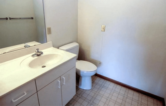 a bathroom with a toilet and a sink and a mirror