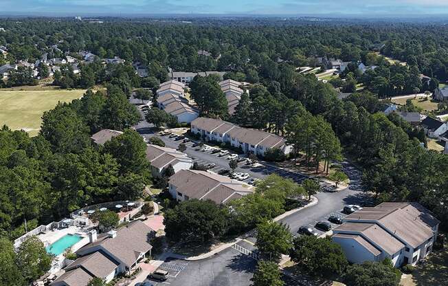 A bird's eye view of a residential area with houses and a swimming pool.