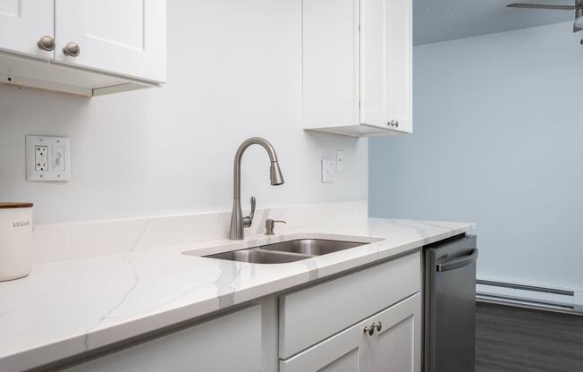 a kitchen with white cabinets and a sink