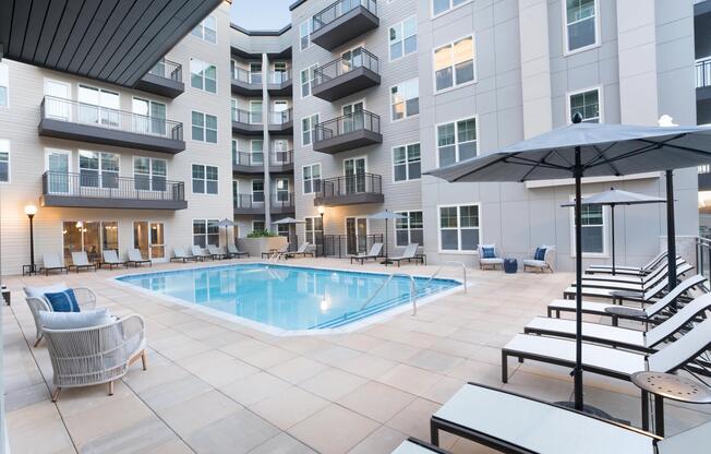 A resort-style pool anchors the courtyard at Modera Liberty Row, with lounge seating and balconies creating a relaxed, social setting in Charlotte.