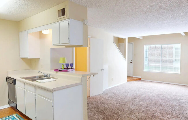 A kitchen with white cabinets and a sink.