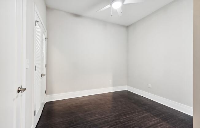 a bedroom with a hardwood floor and a ceiling fan