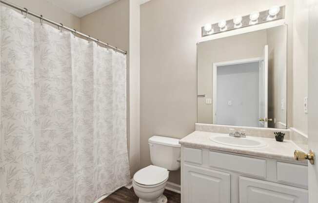 a bathroom with a shower and a toilet and a sink