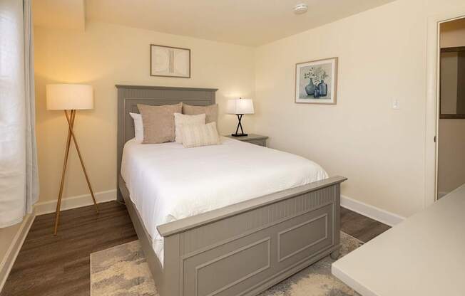 A bedroom with a large bed and two lamps.