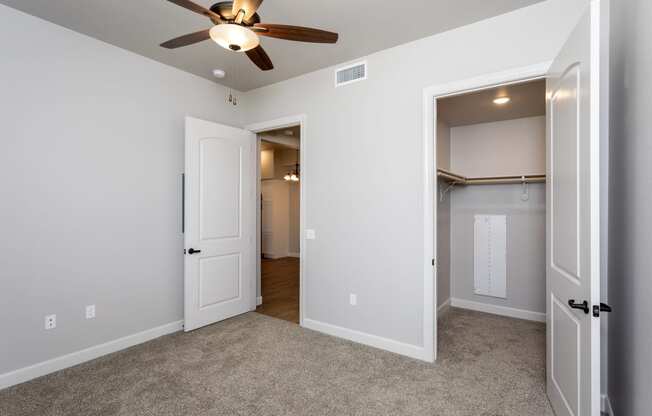 a bedroom with a ceiling fan and closet