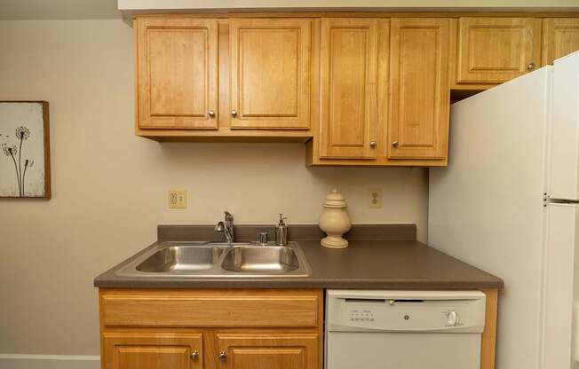 A kitchen with wooden cabinets and a white refrigerator.