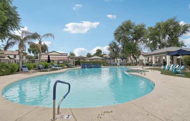 a resort style pool with chairs and umbrellas