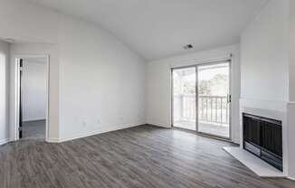 A room with a fireplace and sliding glass doors.