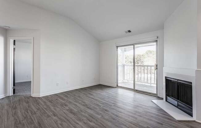 A room with a fireplace and sliding glass doors.