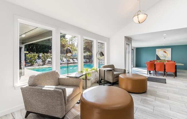 A living room with a pool outside the window.