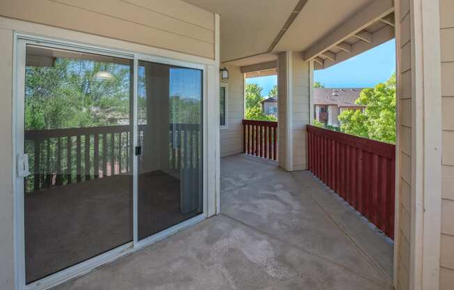 a covered porch with glass doors and a patio