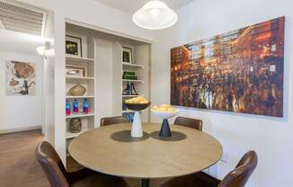A dining room with a round table and chairs.