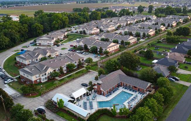 an aerial view of a neighborhood of houses with a swimming pool