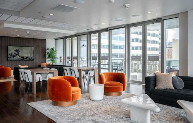 a living room with orange chairs and a table with a couch