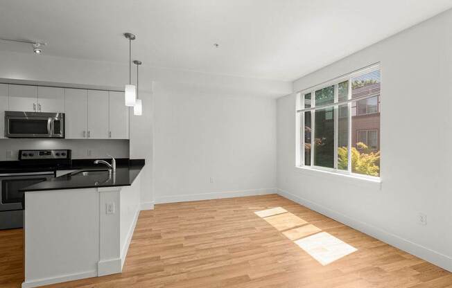 A kitchen with a black countertop and white cabinets.