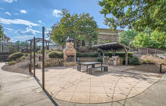 a courtyard with a picnic table and a stone gazebo