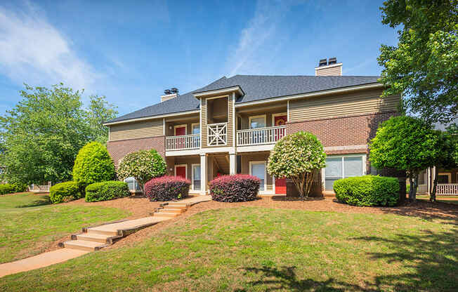 Exterior Of Apartment Homes With Lush Landscaping In Front