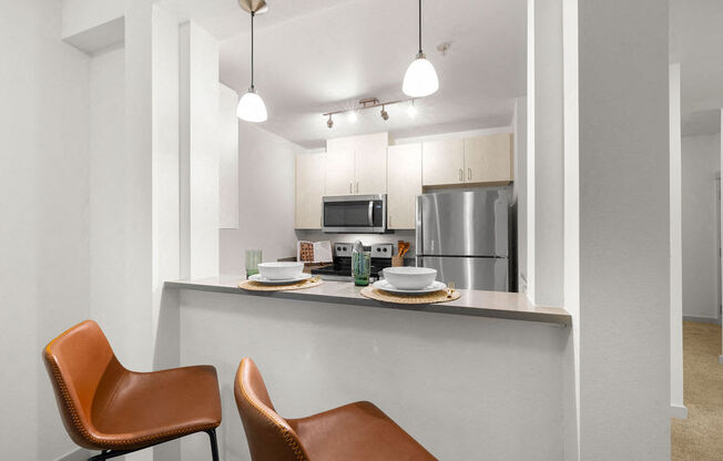 a kitchen with a counter top and a stainless steel refrigerator