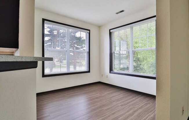 A room with a window overlooking a tree-filled yard.