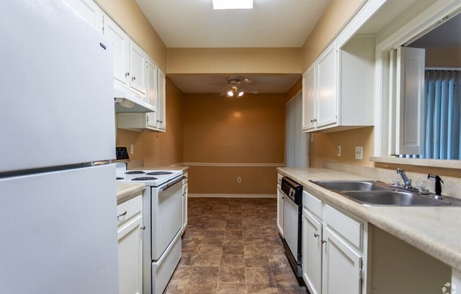 a kitchen with white appliances and white cabinets