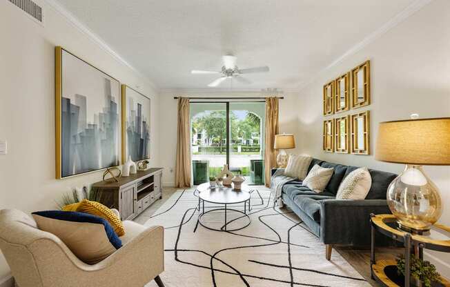 a living room with a couch and chairs and a ceiling fan