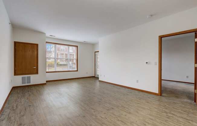 an empty living room with wood floors and white walls