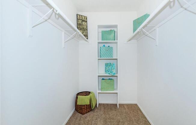 a closet with shelves and a basket on the floor