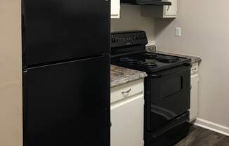 kitchen with black fridge and oven, range, and hardwood-style floor