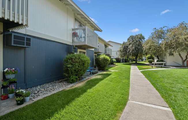 A walkway leads through a grassy area between two buildings.