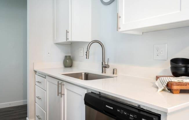 a kitchen with white cabinets and a sink