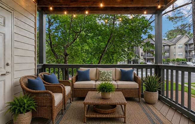 A patio with a couch, chairs, and a coffee table.