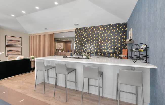 a kitchen with a white counter top and three stools