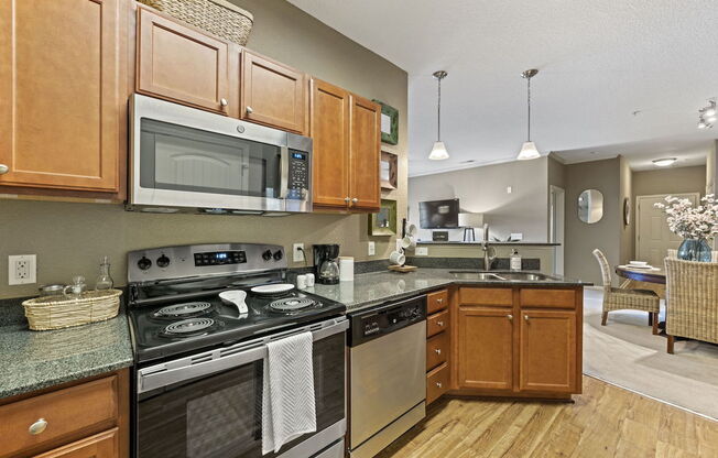 kitchen with stainless steel appliances, granite countertops, and wood cabinets at Fenwyck Manor
