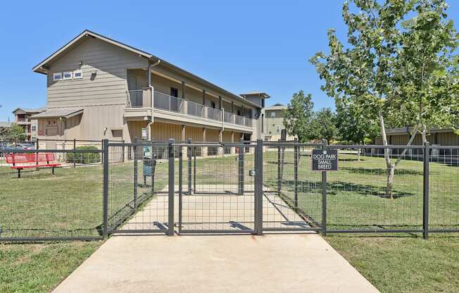 A gated entrance to a building with a sign on the fence.
