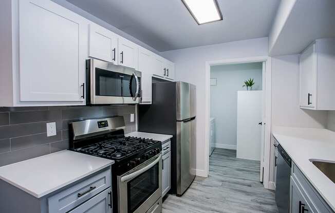 a kitchen with white cabinets and stainless steel appliances