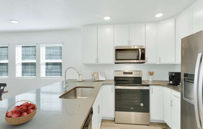 a kitchen with white cabinets and stainless steel appliances