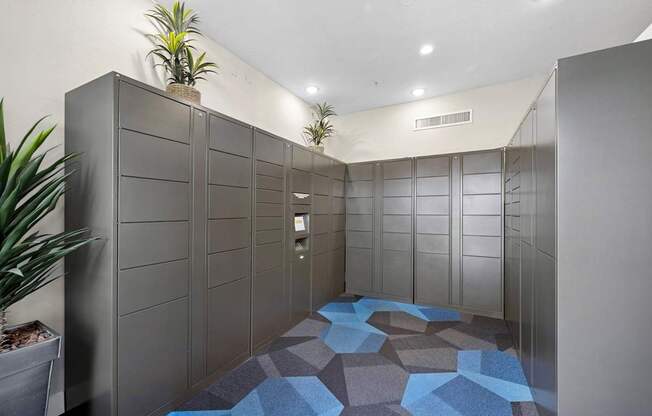 A hallway with a blue tiled floor and grey walls.