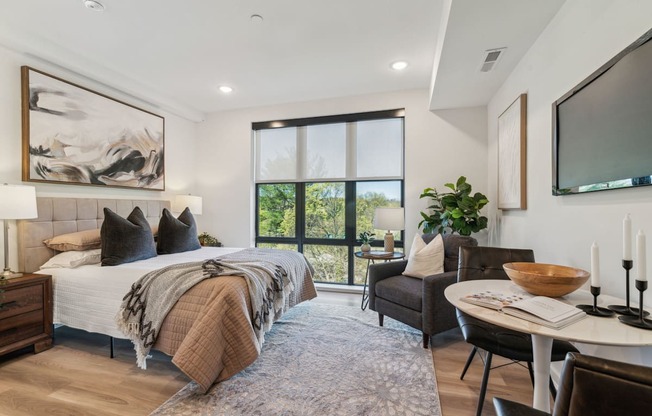 A bedroom with a large bed and a chair.