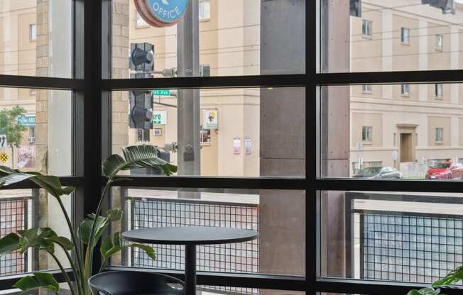 a table and two chairs in front of a window with a view of a building