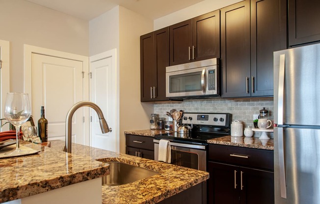 a kitchen with granite countertops and black cabinets