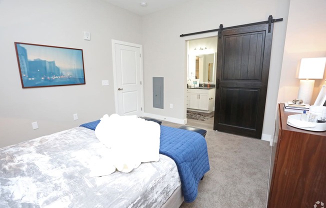 a bedroom with a bed and a sliding door to a bathroom at Century Baxter Avenue, Kentucky